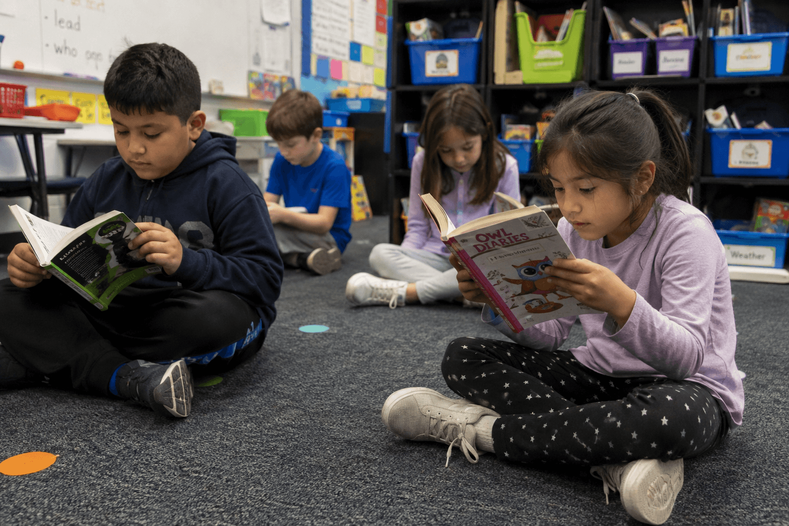 Elementary students reading independently together in a classroom